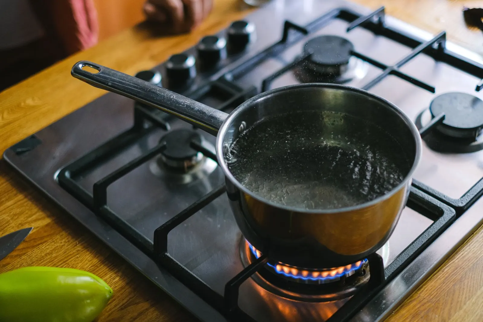A saucepan of tap water at a rolling boil on a gas stove during a boil water advisory